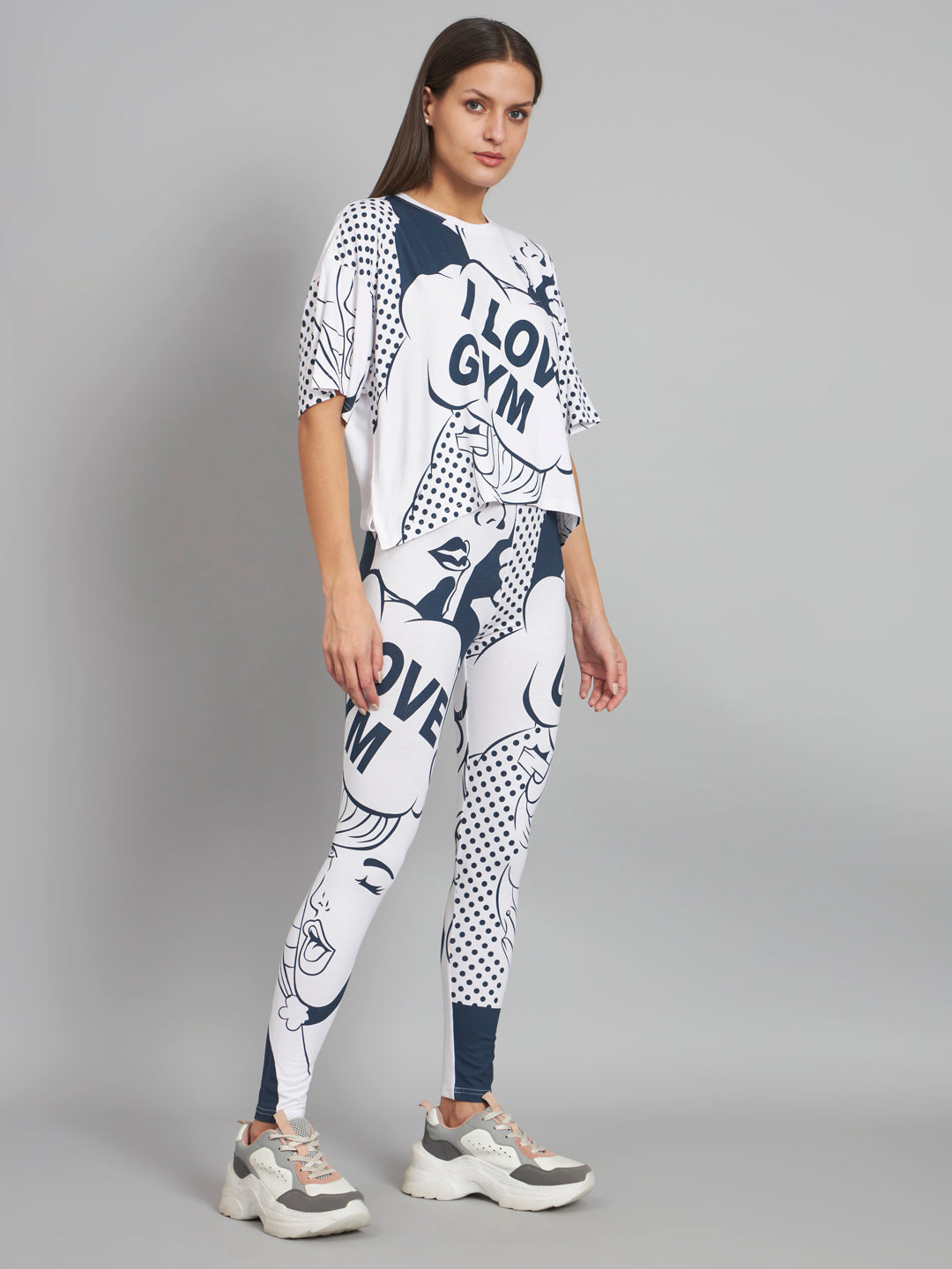 Woman wearing a white and navy gym-themed outfit on a gray background